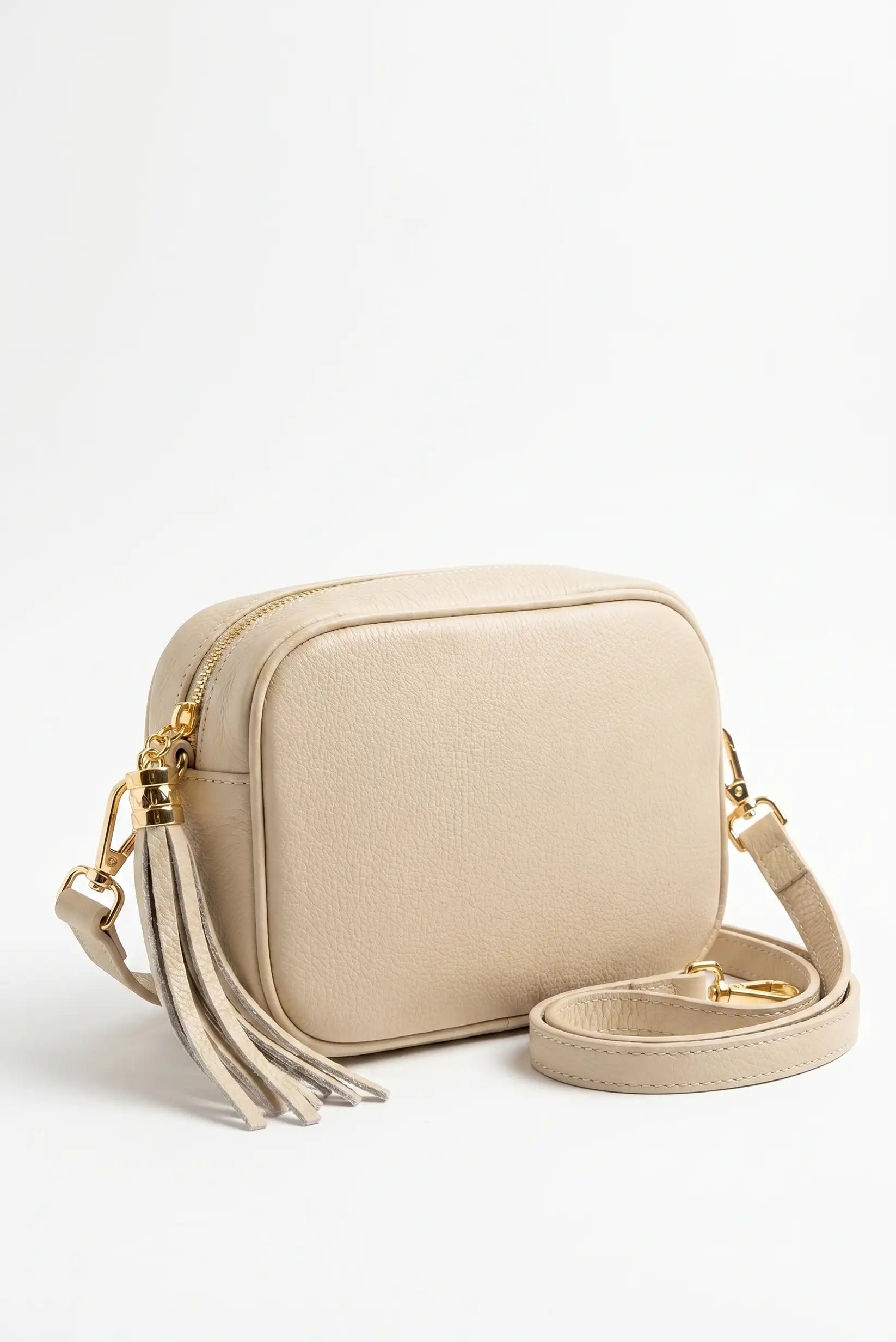 Bolso bandolera beige de piel sintética con correa ajustable y decoración de flecos dorados
