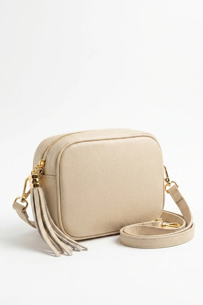 Bolso bandolera beige de piel sintética con correa ajustable y decoración de flecos dorados