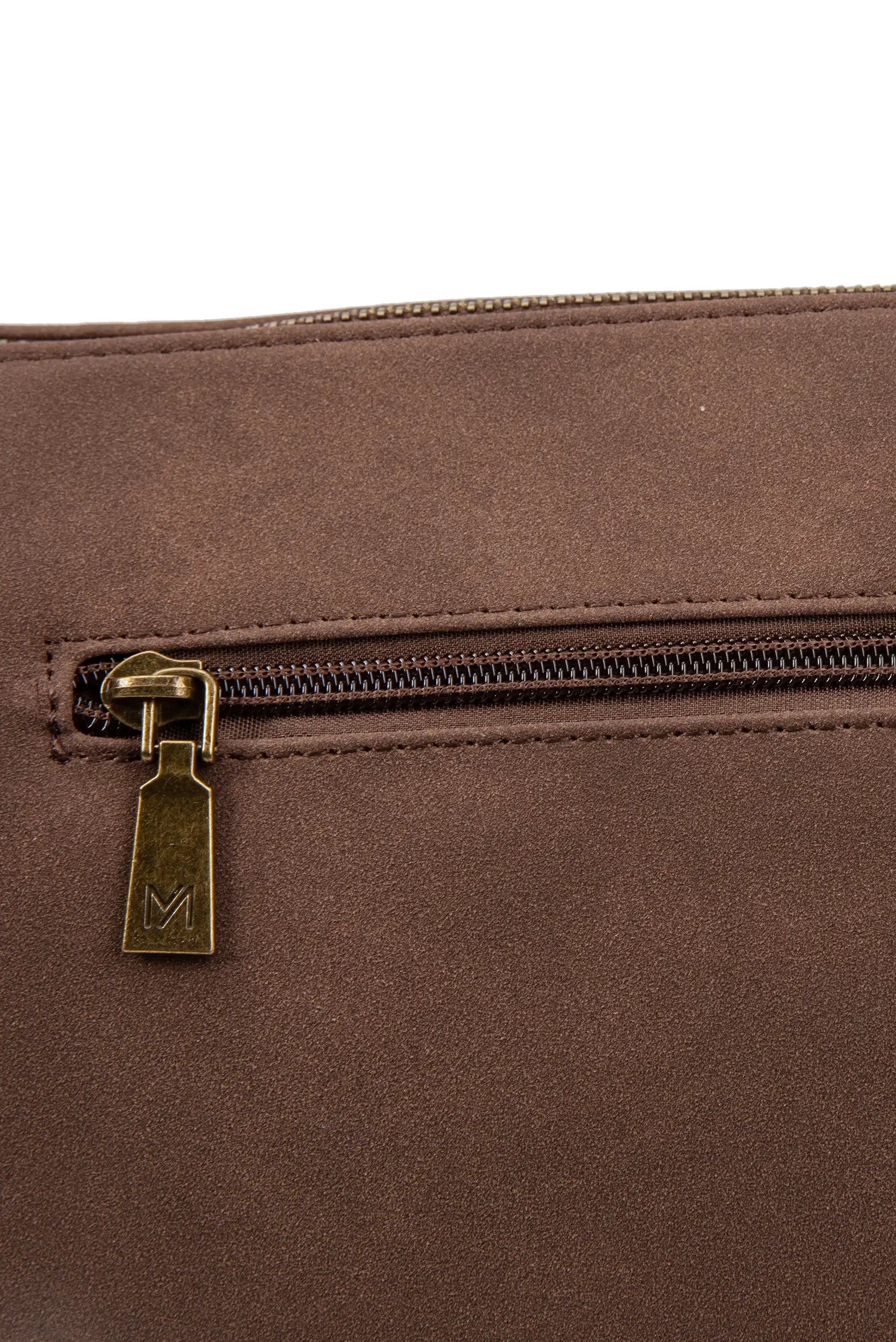 Detalle de cremallera dorada con logo M en bolso marrón de textura suave, complemento femenino elegante