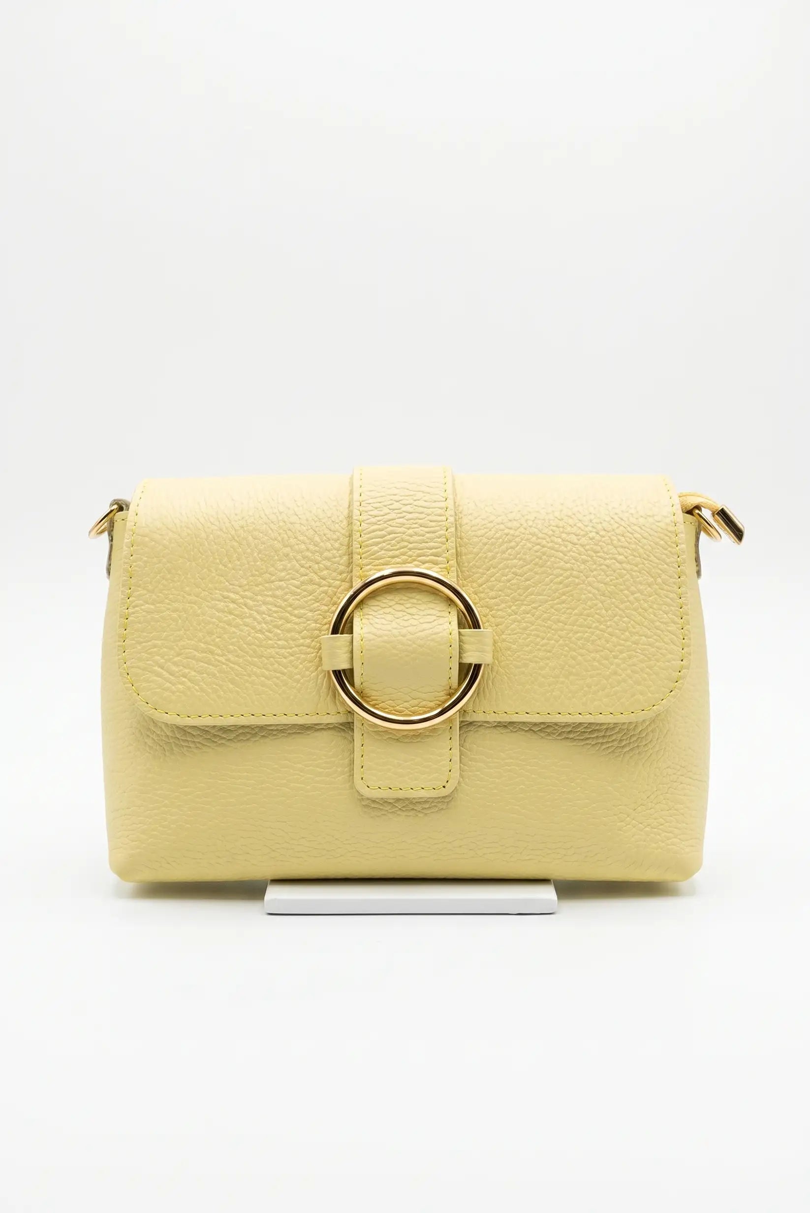 Bolso bandolera pequeño para mujer en color amarillo, con textura y hebilla dorada frontal.