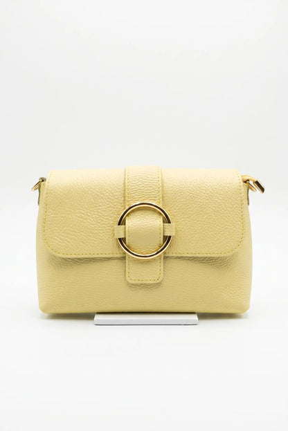 Bolso bandolera pequeño para mujer en color amarillo, con textura y hebilla dorada frontal.