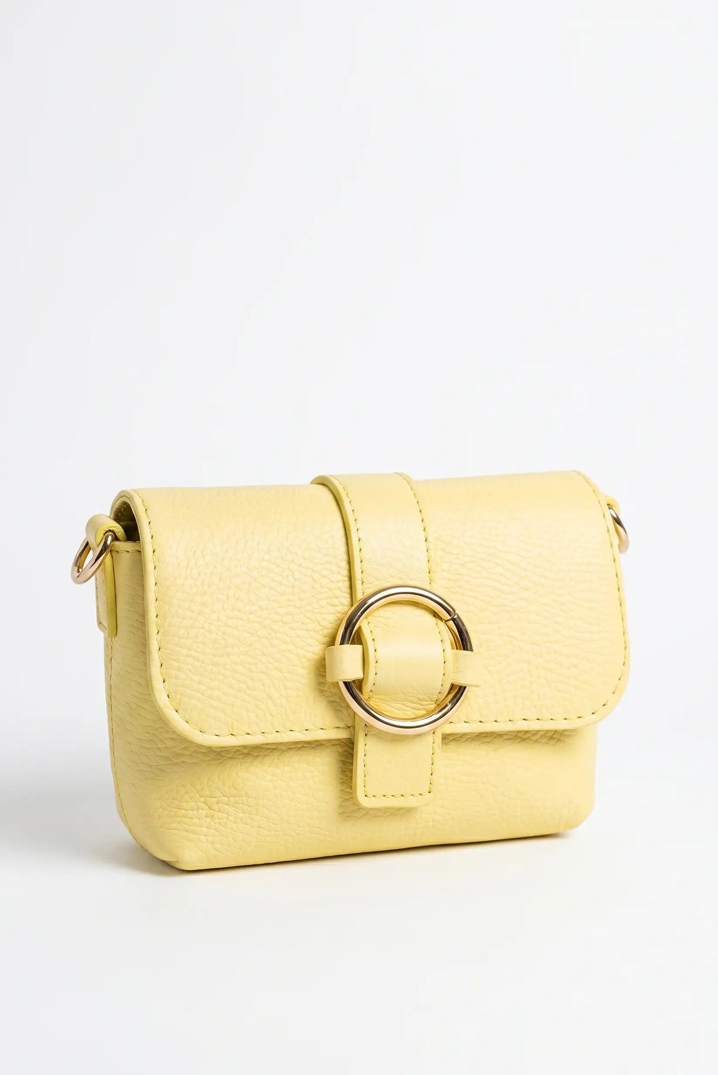 Bolso bandolera pequeño de piel amarillo con cierre de aro dorado sobre fondo blanco