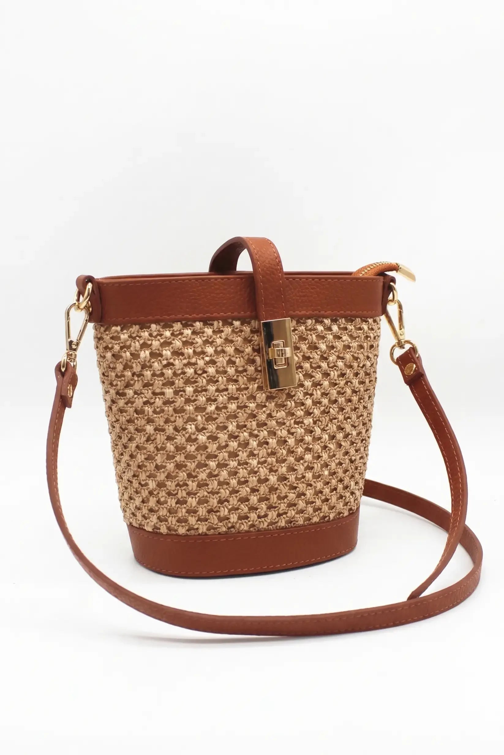 Bolso bandolera de rafia beige con detalles de piel marrón y cierre dorado elegante.