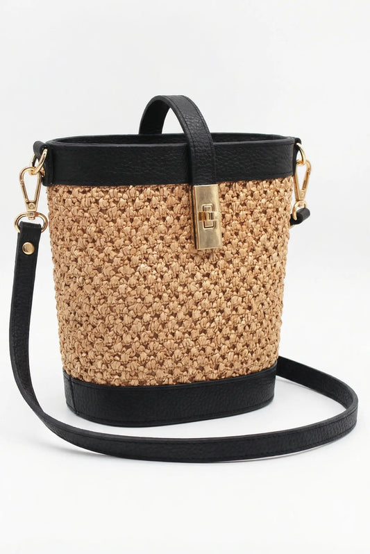 Bolso bandolera de rafia beige con detalles y correa de piel sintética negra, cierre dorado.