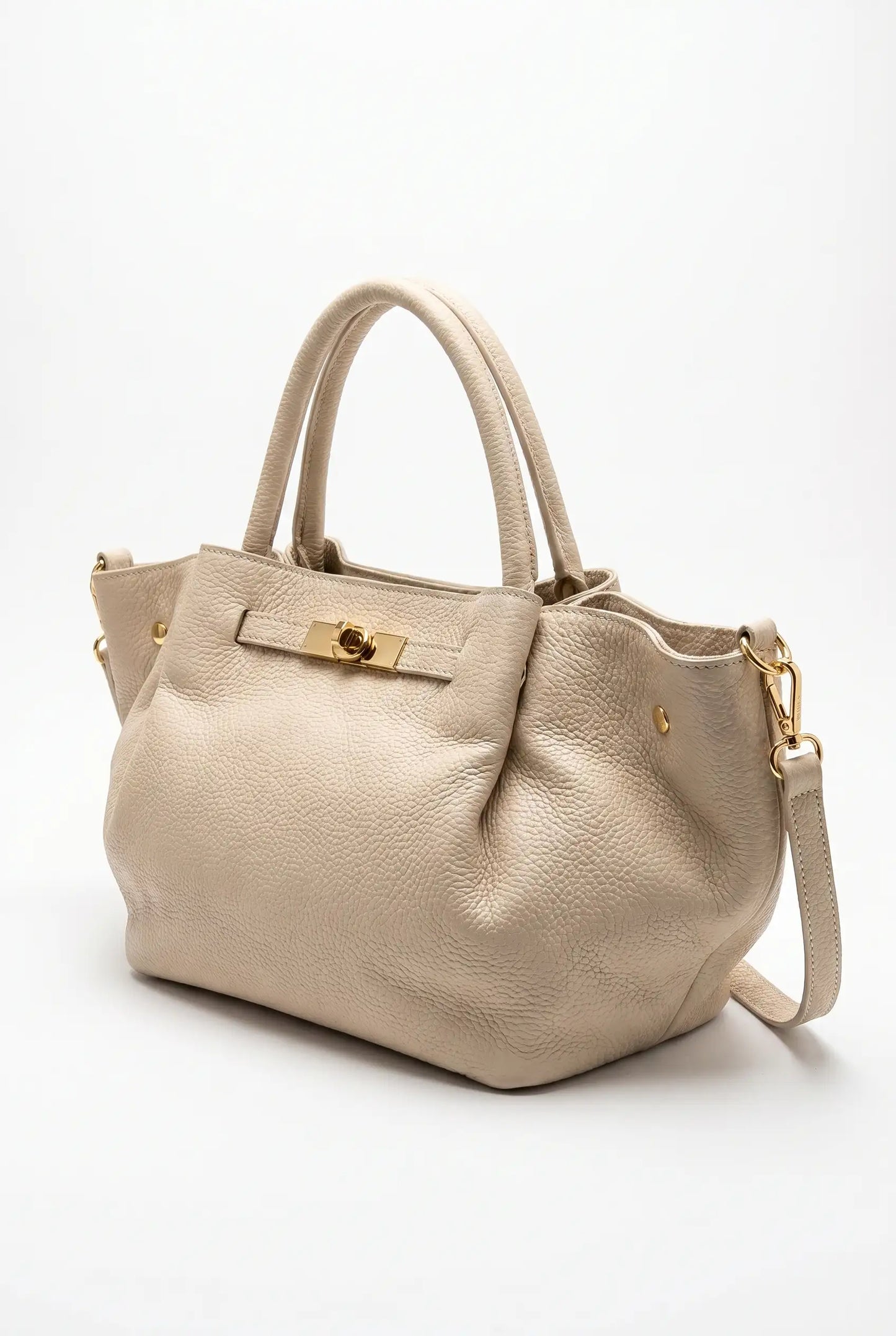 Bolso grande beige de piel con asas cortas, cierre dorado y correa ajustable, estilo elegante.