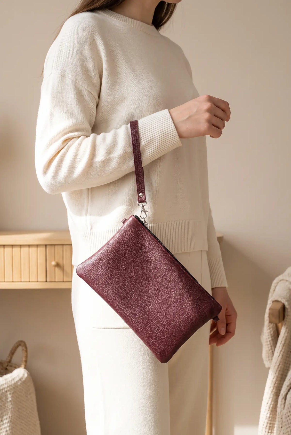 Mujer con jersey blanco y bolso clutch de piel burdeos de CHICA del Sur