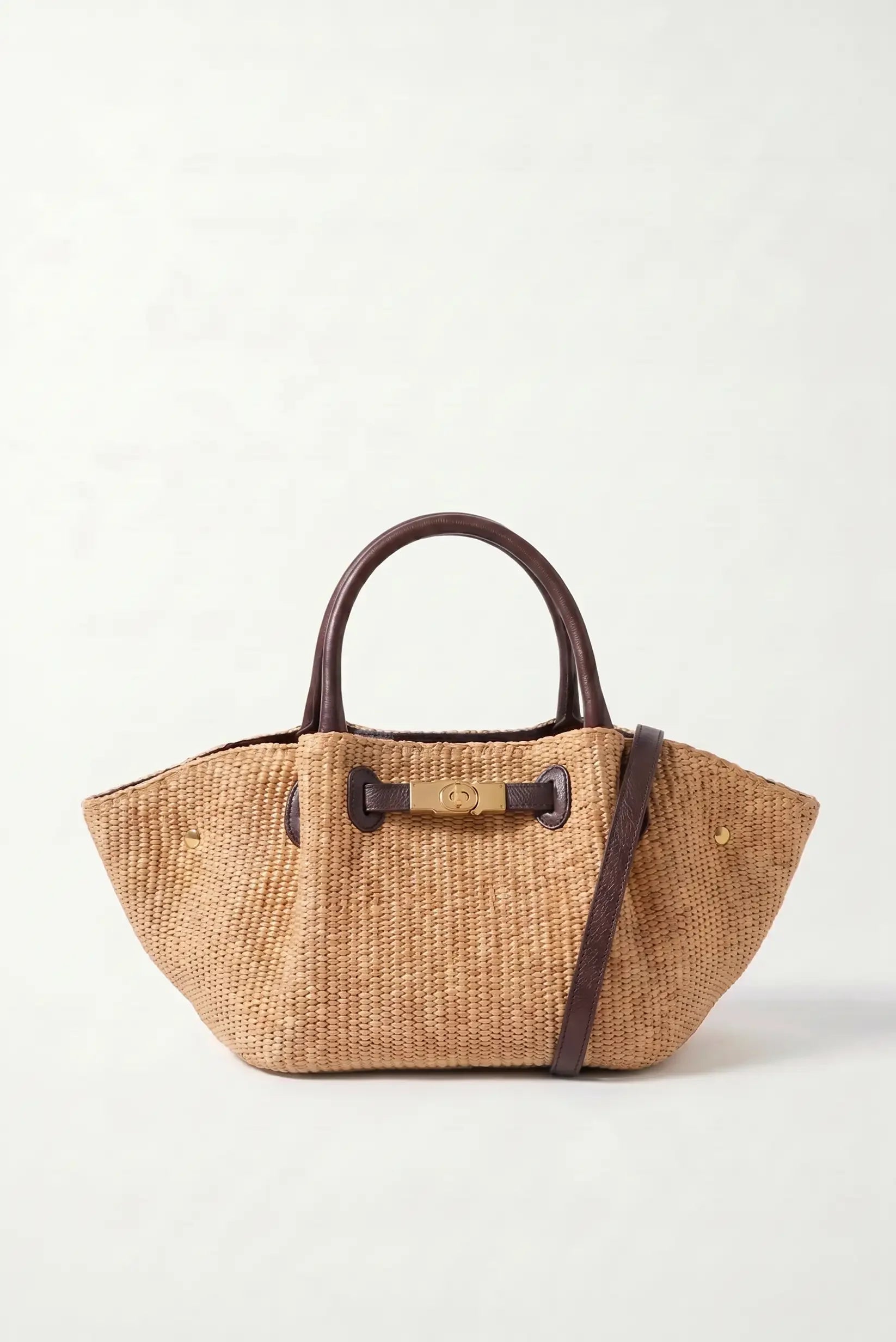Bolso de paja tejida con asas de cuero marrón y cierre metálico dorado, ideal para verano y playa