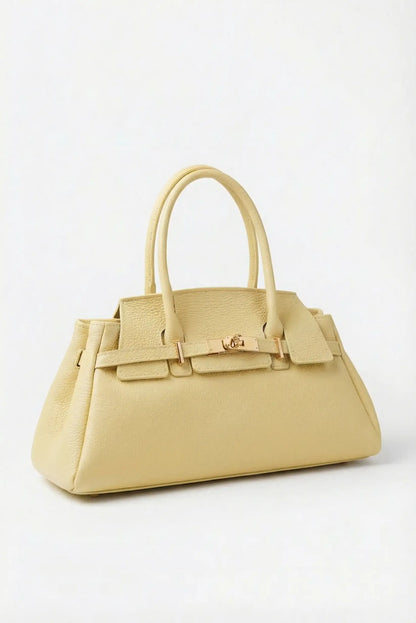 Bolso de mano amarillo pastel de piel para mujer, estilo elegante, sobre fondo claro.