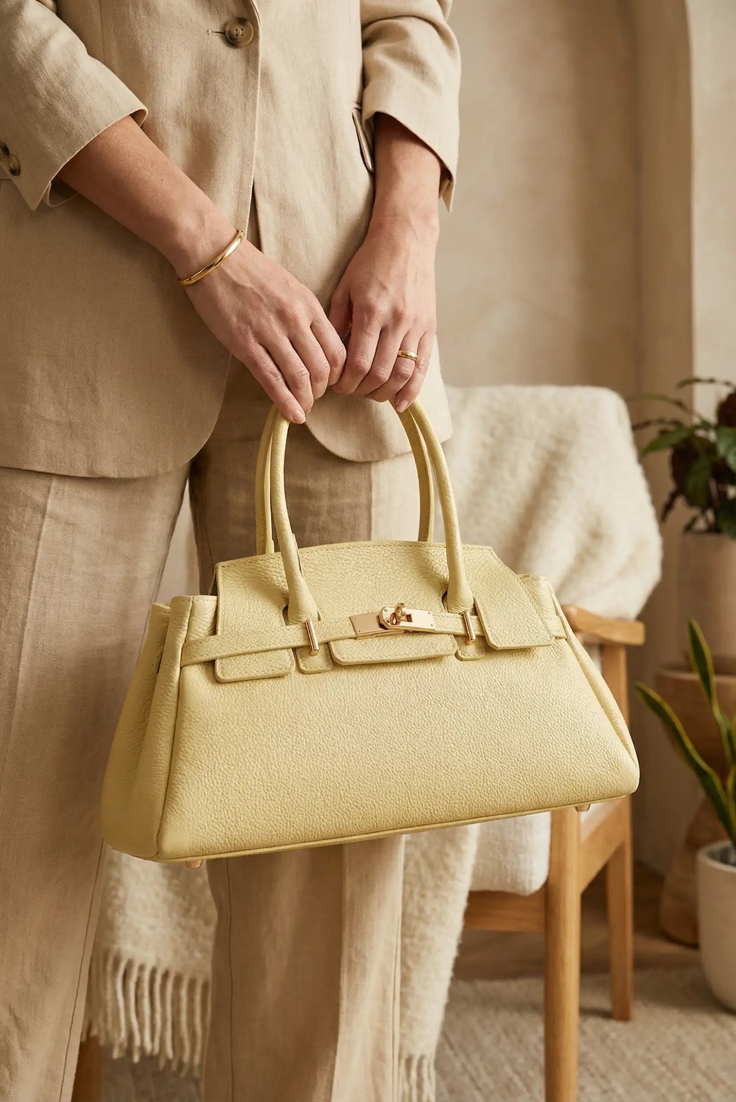 Bolso de mano amarillo pastel de piel para mujer, elegante y moderno, en ambiente cálido