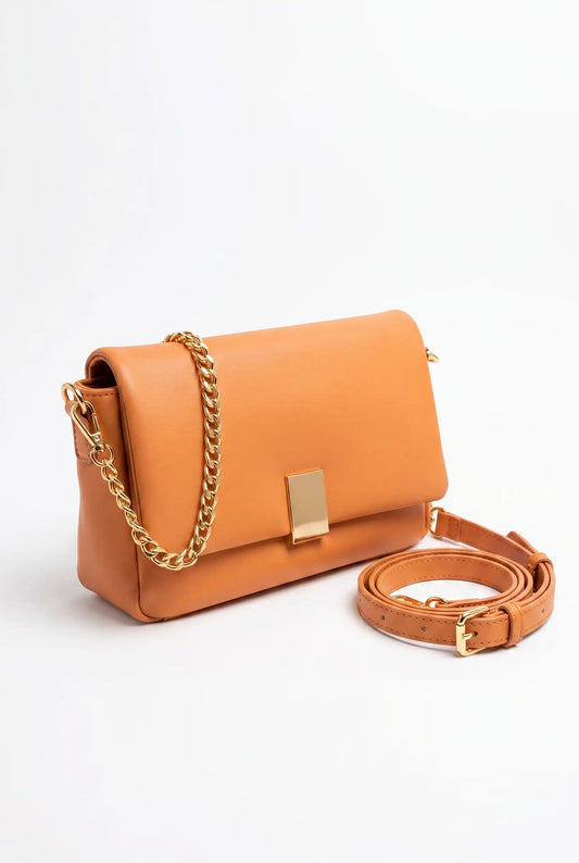 Bolso bandolera de polipiel naranja con cadena dorada y correa ajustable, estilo moderno.