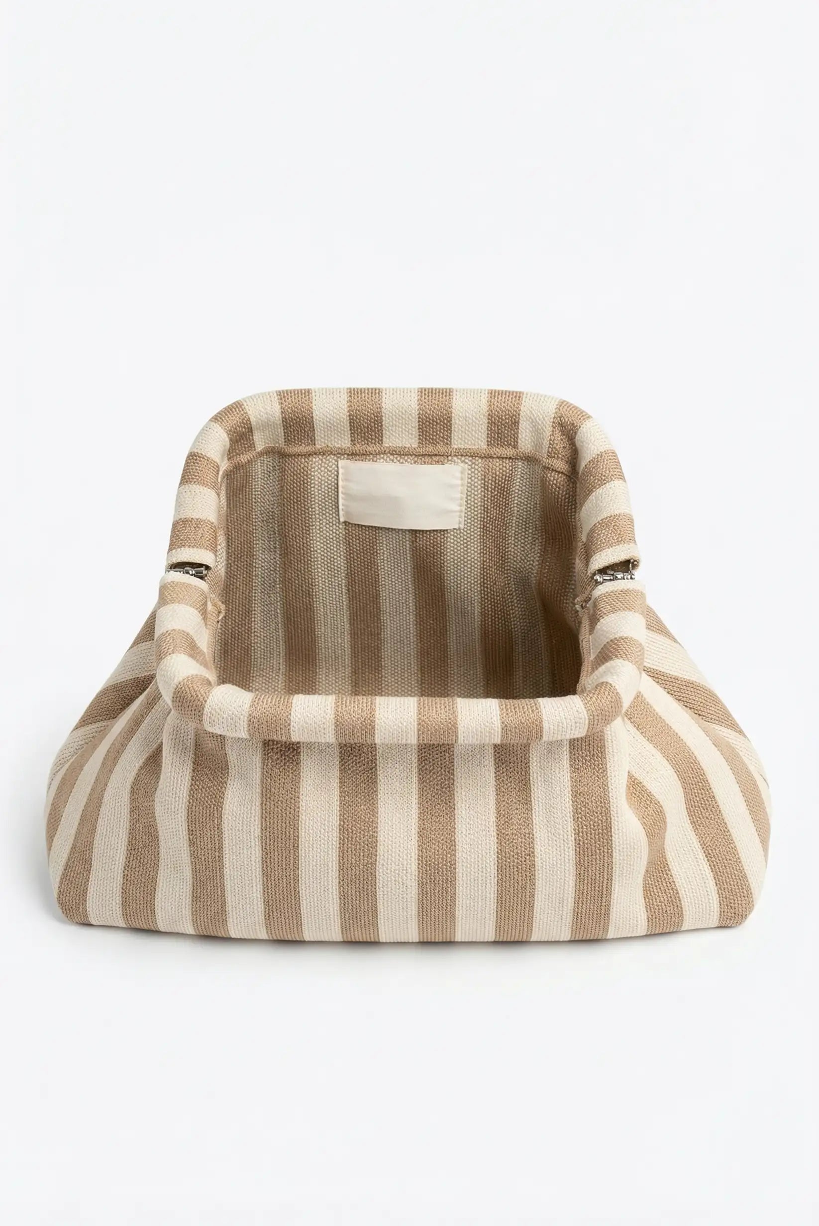 Bolso de mano tipo clutch beige y blanco con rayas verticales, estilo casual femenino.