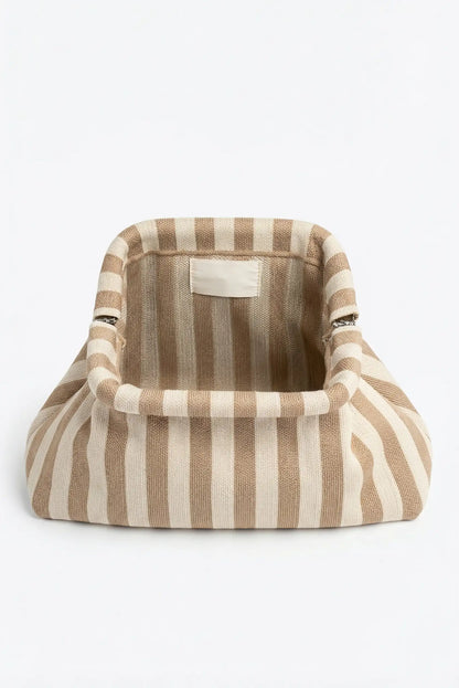 Bolso de mano tipo clutch beige y blanco con rayas verticales, estilo casual femenino.