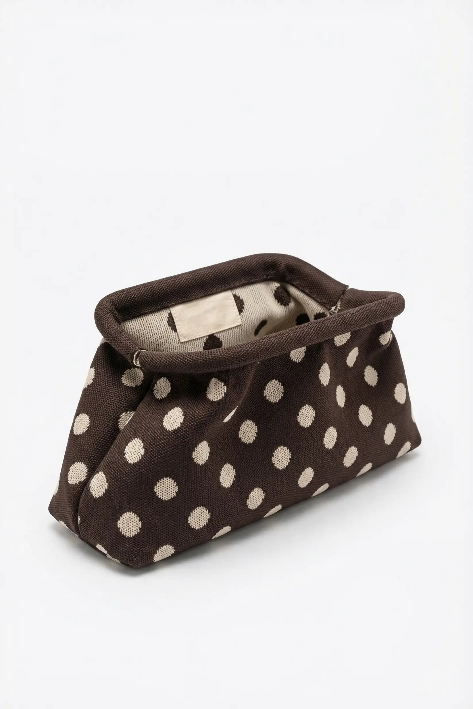 Bolso de mano clutch marrón chocolate con topos beige, estilo parisino, fondo blanco