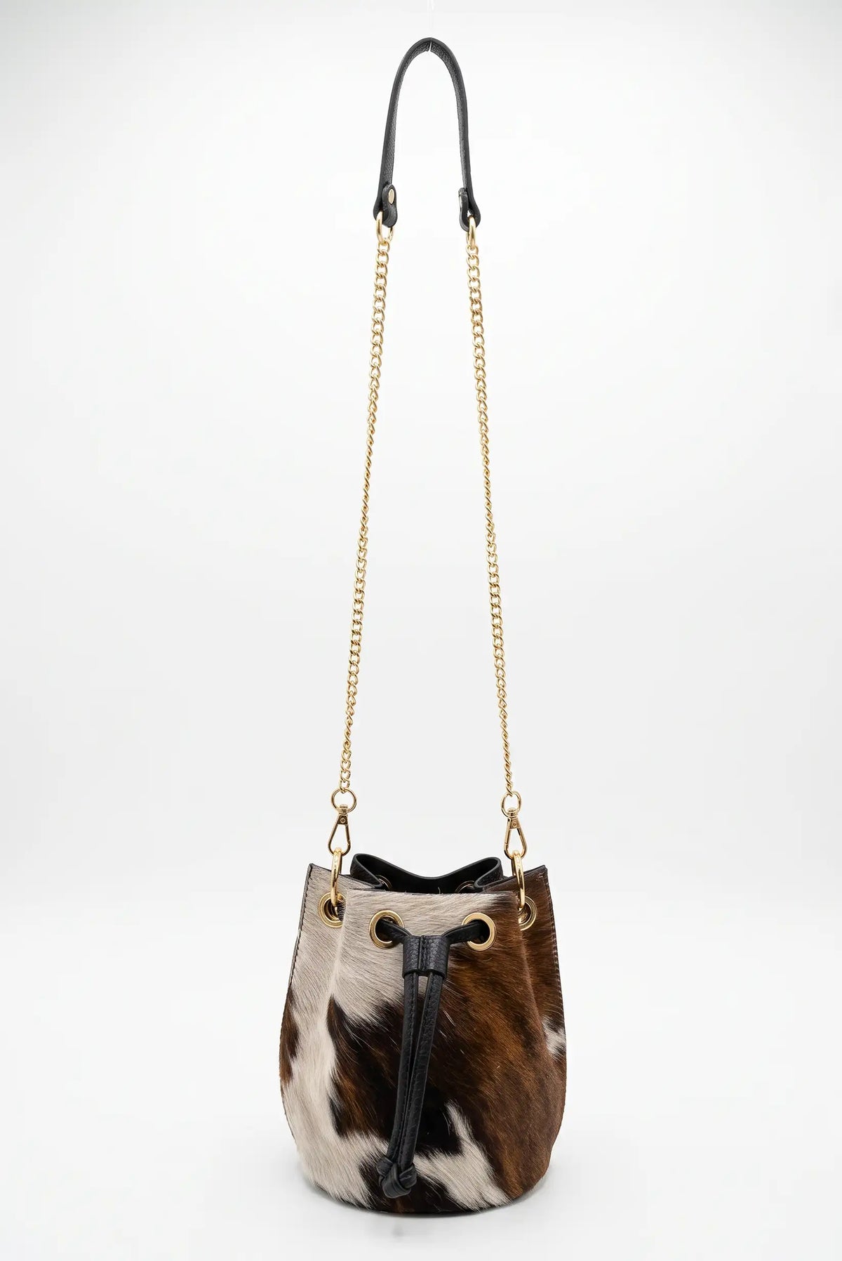 Bolso saco de mujer con estampado de vaca en pelo de potro y asa de cadena dorada de CHICA del Sur