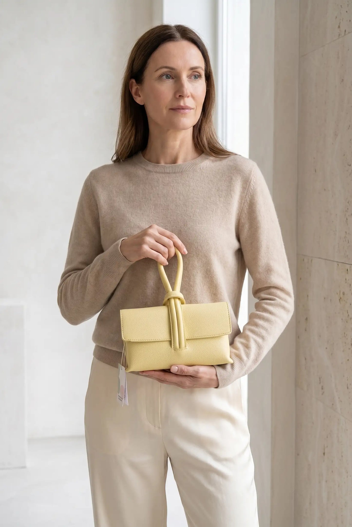 Mujer con bolso de mano pequeño amarillo tipo nudo, estilo casual y femenino