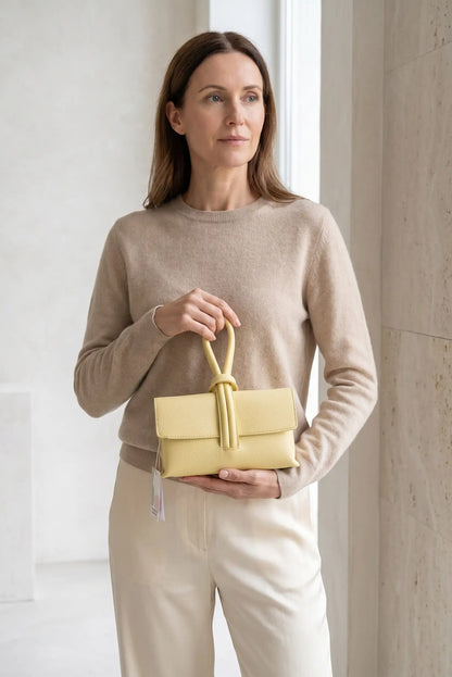 Mujer con bolso de mano pequeño amarillo tipo nudo, estilo casual y femenino
