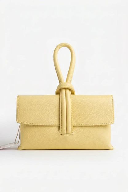 Bolso de mano pequeño de piel amarillo con cierre tipo nudo, estilo bandolera elegante.