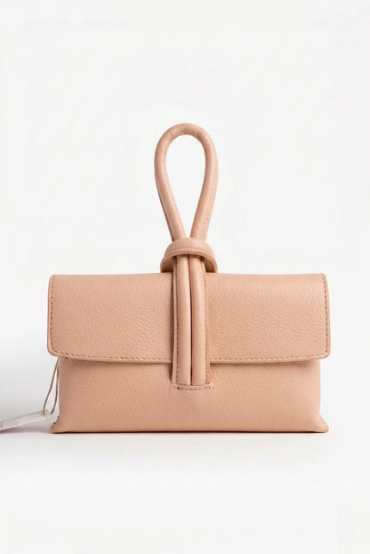 Bolso de mano pequeño nude de piel con asa tipo nudo, fondo blanco, estilo casual elegante