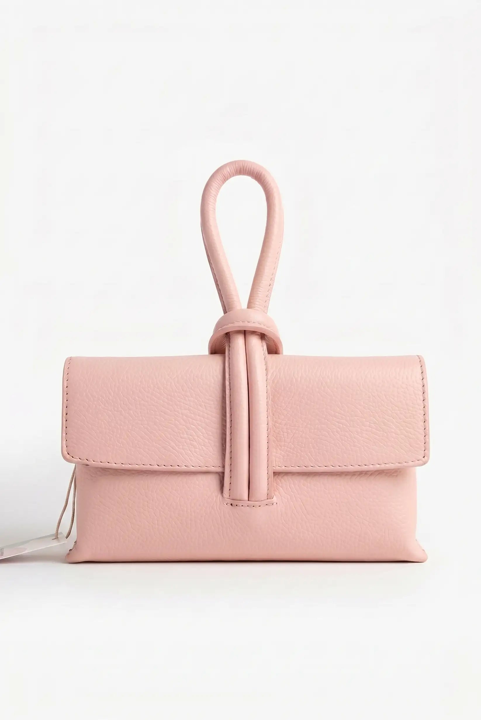 Bolso de mano pequeño rosa de piel con cierre tipo nudo y textura suave, fondo blanco.