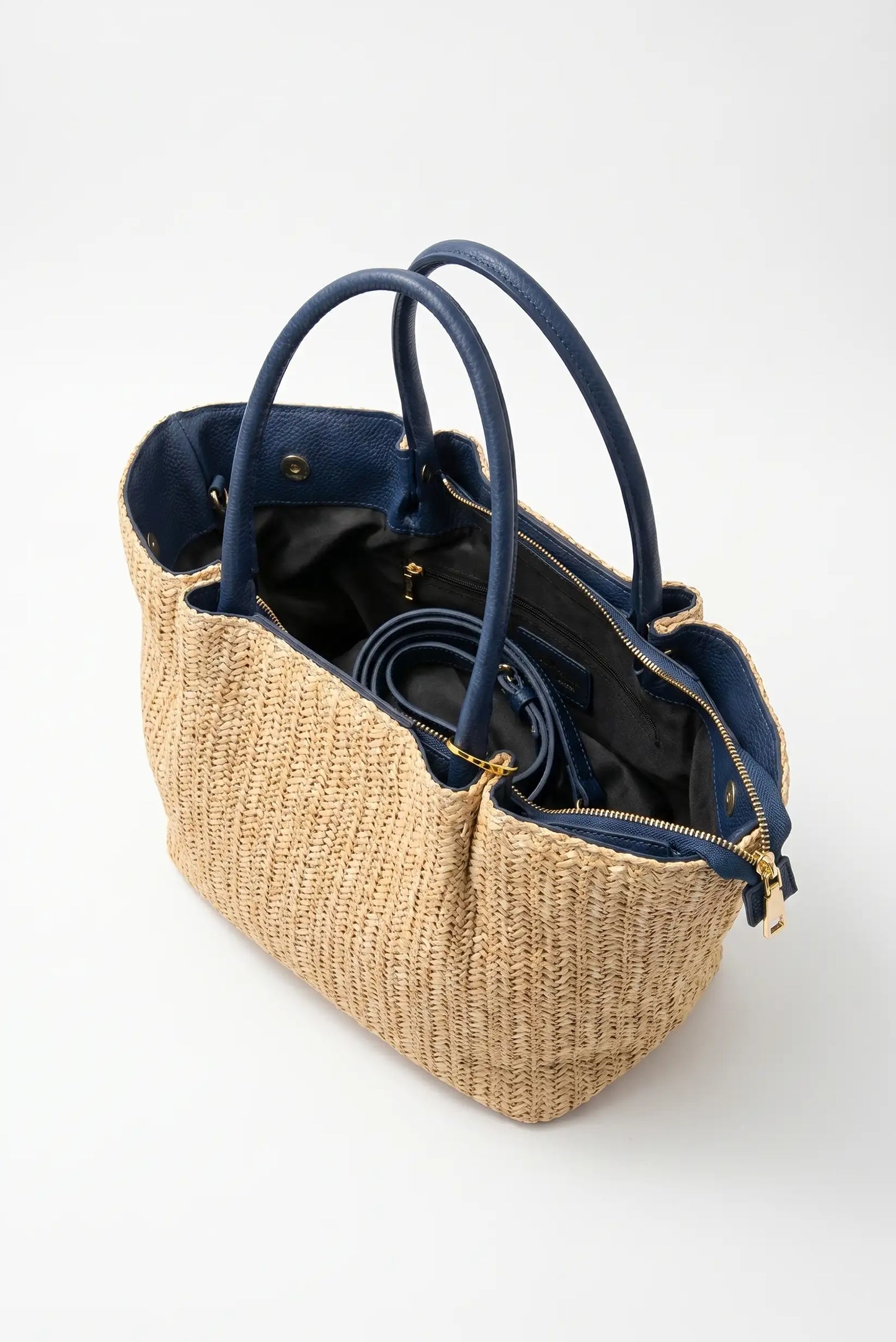 Bolso de mano de rafia con detalles en piel azul marino y asa interna, elegante y casual.
