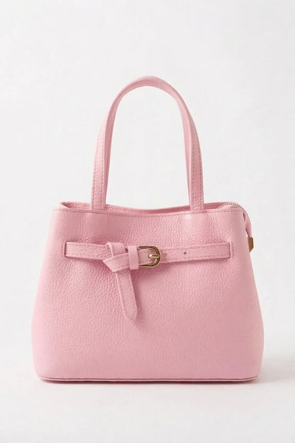Bolso mediano rosa pastel con asa doble y detalle de hebilla dorada, fondo blanco.