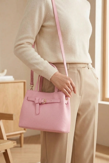 Bolso mediano rosa pastel tipo bandolera de moda femenina, detalle con hebilla dorada.