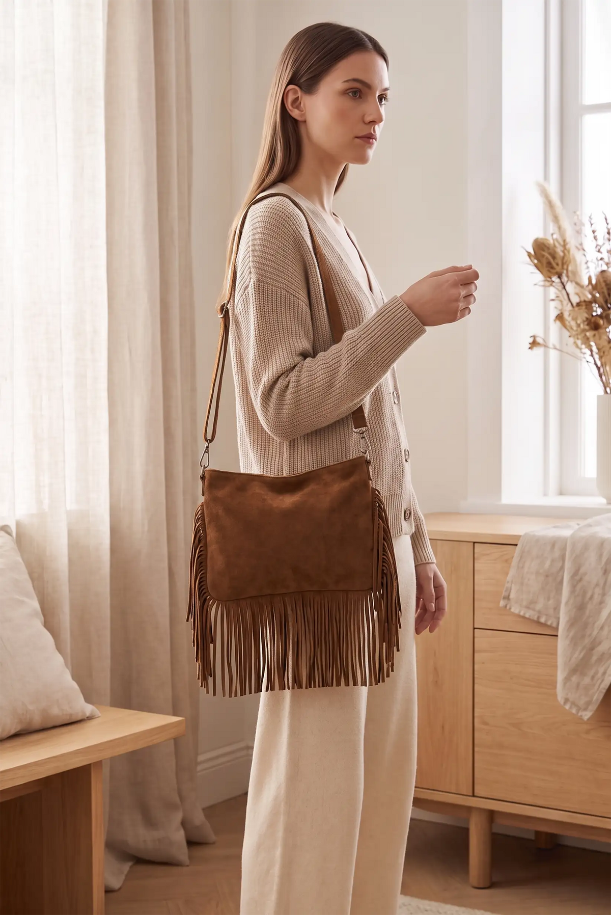 Mujer con bolso camel tipo ante con flecos de CHICA del Sur y jersey beige