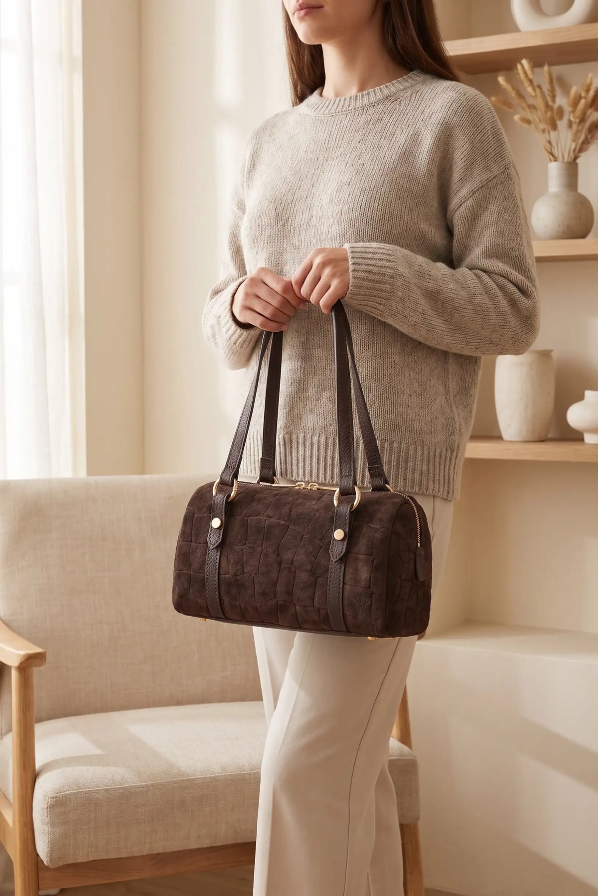 Mujer con jersey beige sosteniendo un bolso marrón chocolate tipo ante de CHICA del Sur