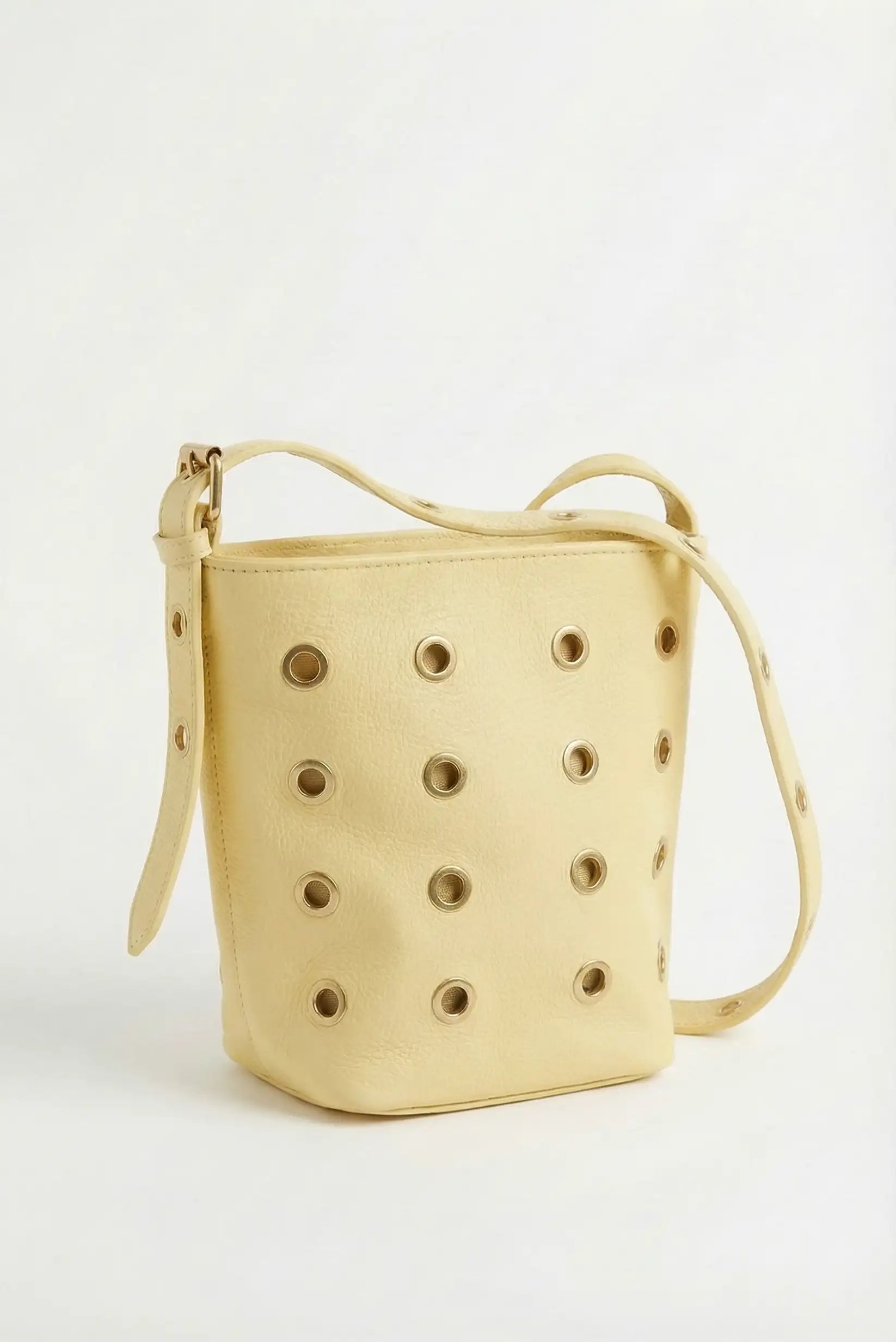 Bolso mediano amarillo pastel de piel sintética con tachuelas doradas y correa ajustable