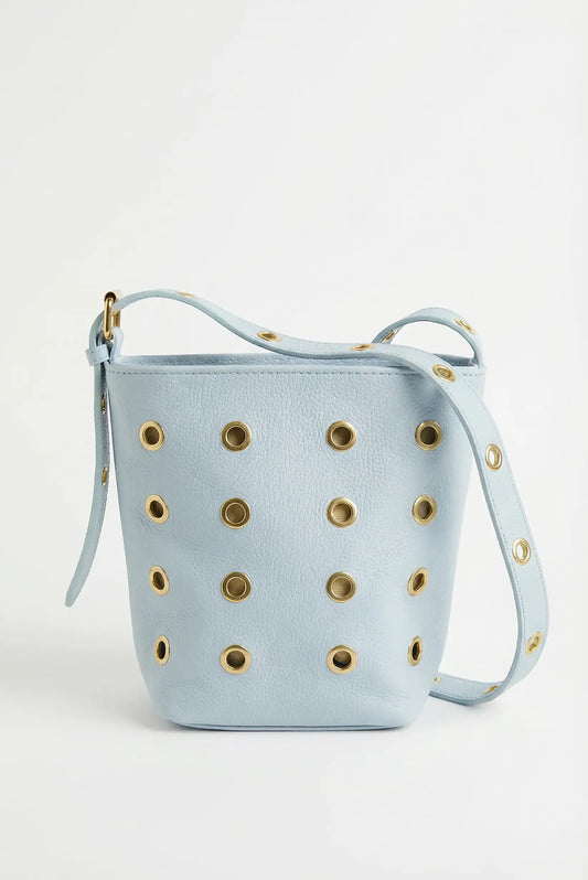 Bolso mediano azul pastel de piel con tachuelas doradas y correa ajustable