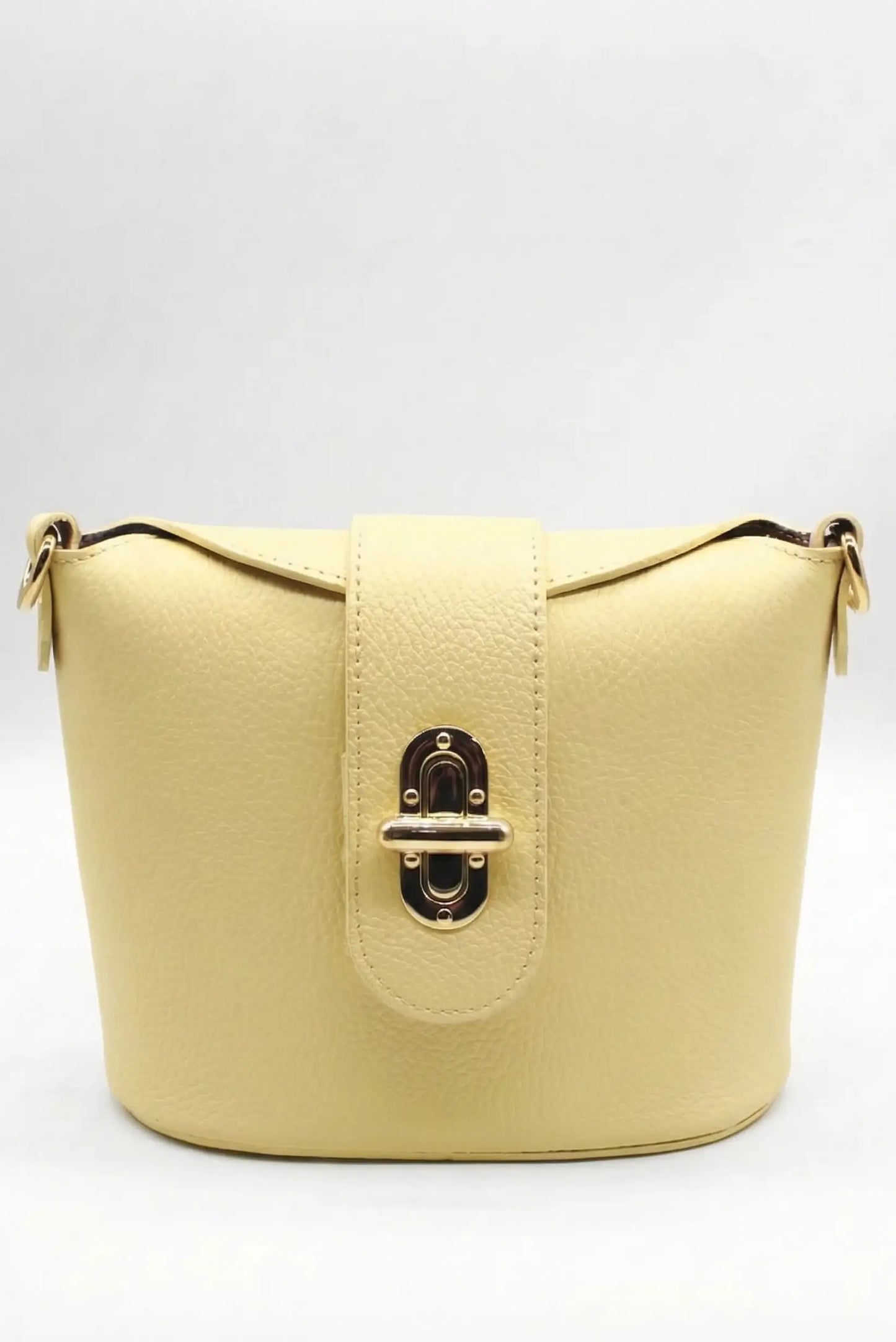 Bolso bandolera mediano para mujer en color amarillo pastel con cierre metálico elegante.