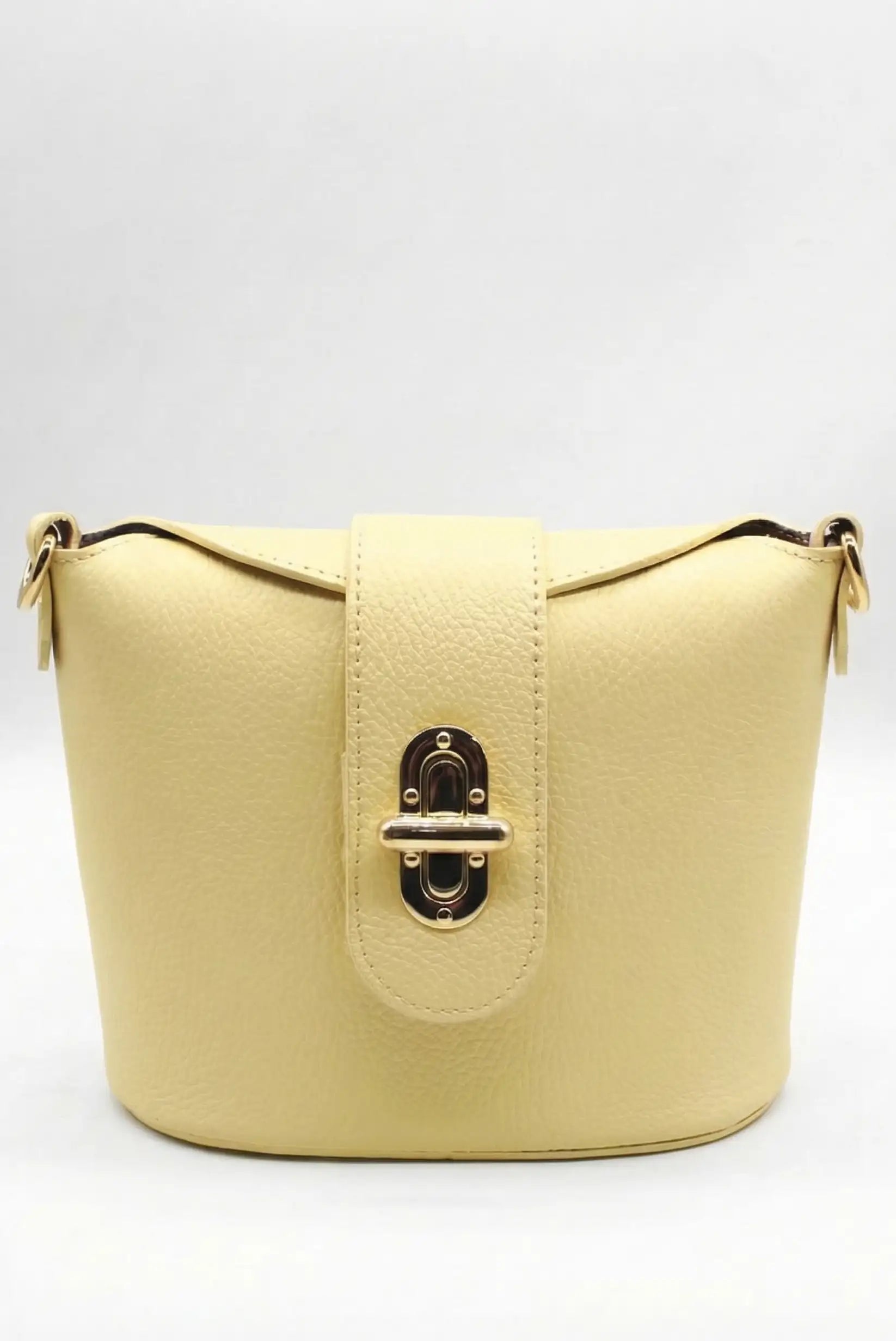 Bolso bandolera mediano para mujer en color amarillo pastel con cierre metálico elegante.