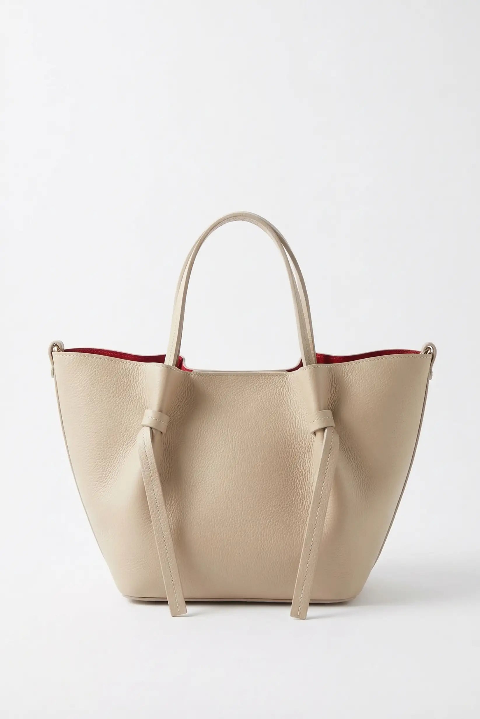 Bolso de mano mediano para mujer en piel beige con asas y forro interior rojo.