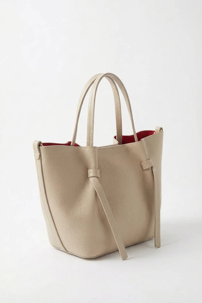 Bolso de mujer mediano de mano en piel beige, interior rojo, estilo casual y elegante.