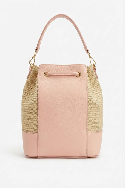 Bolso de mujer tipo saco en rafia beige y piel rosa, con asa corta y detalles dorados.