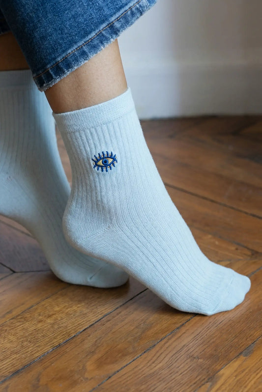 Calcetines mujer azules con bordado ojo turco, moda casual sobre suelo de madera