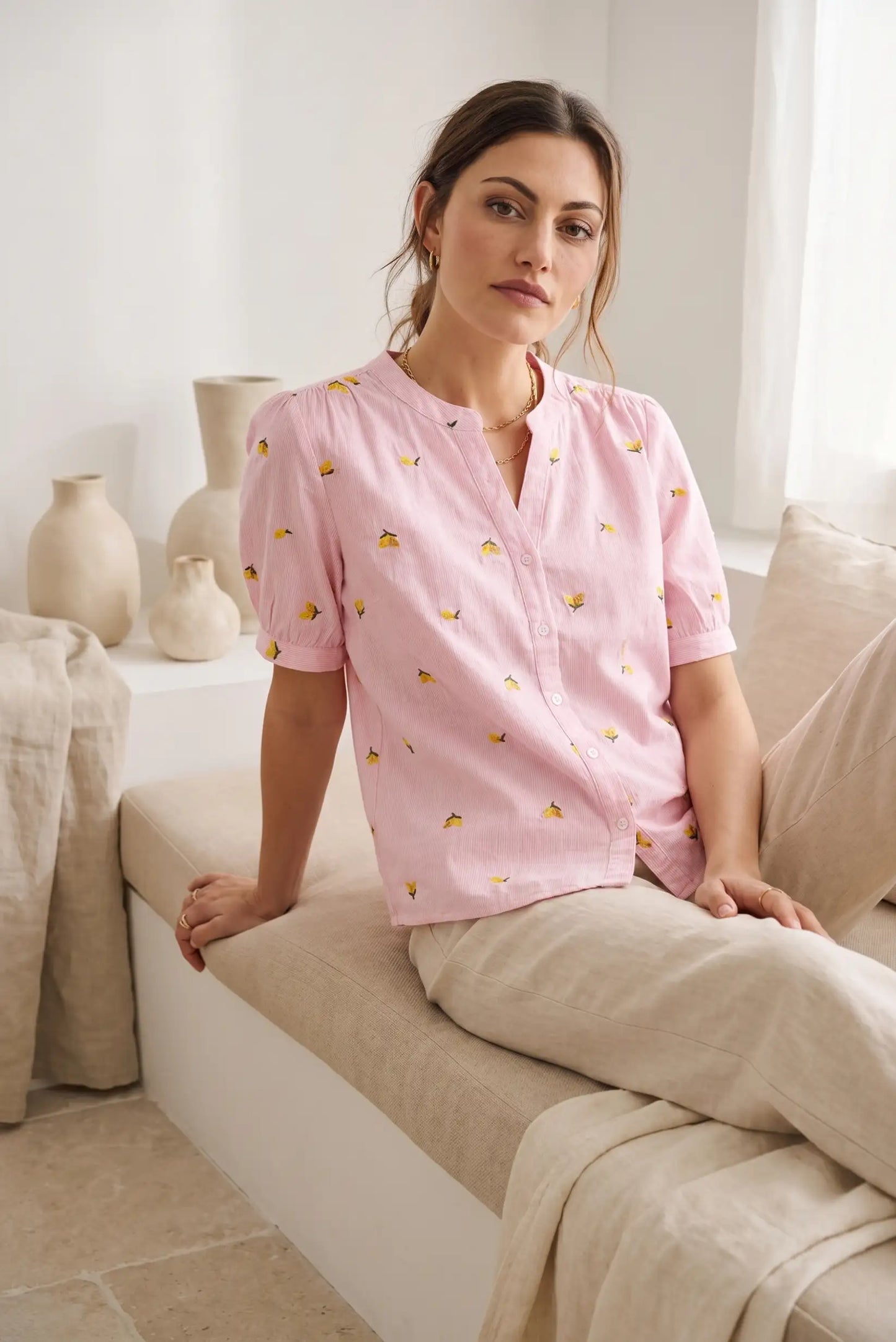 Mujer con camisa rosa de manga corta estampada con limones, look casual y relajado