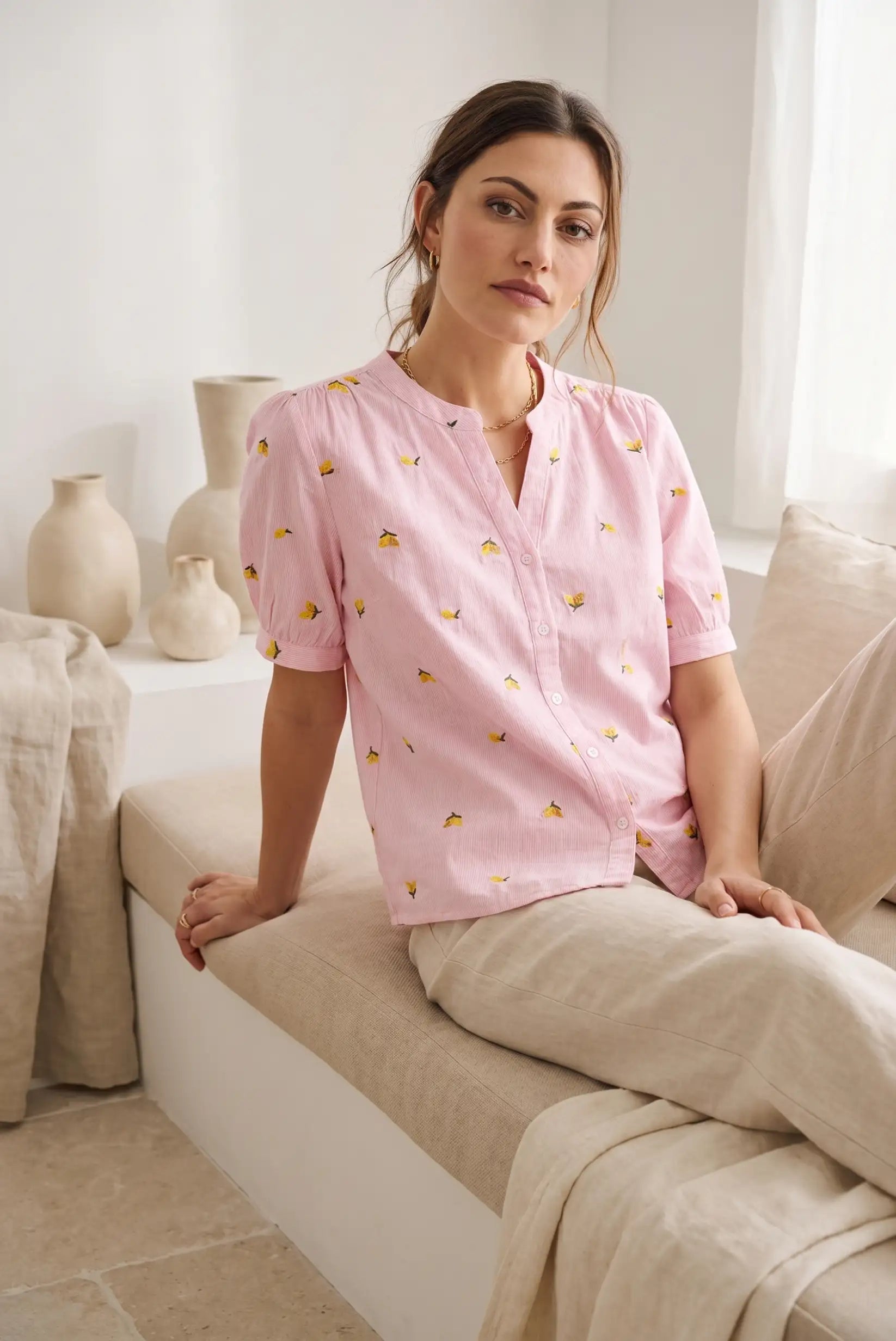 Mujer con camisa rosa de manga corta estampada con limones, look casual y relajado