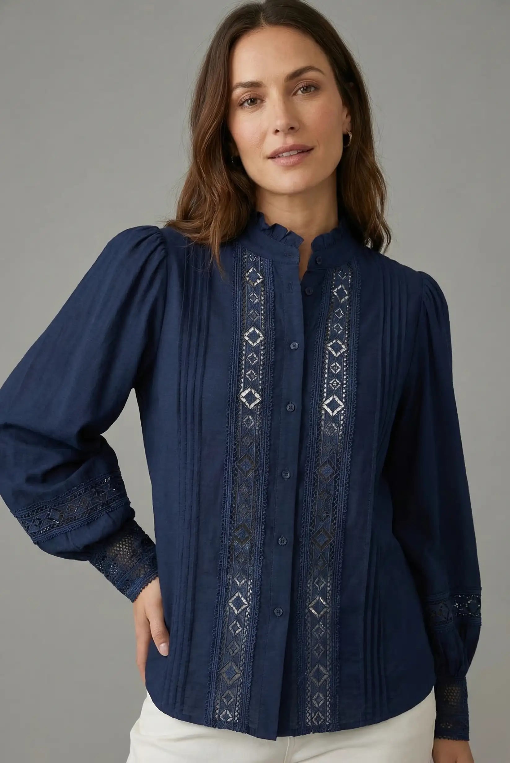 Blusa azul de manga larga con bordados geométricos, cuello mao y tejido ligero.