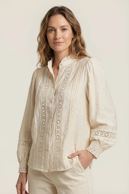 Mujer con camisa beige de manga larga y bordados, look casual primaveral