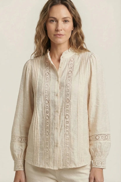 Mujer con camisa beige de manga larga, bordados y encaje, estilo casual primaveral