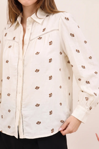 Camisa blanca con bordado floral marrón, manga larga y detalles de encaje, ideal para moda femenina