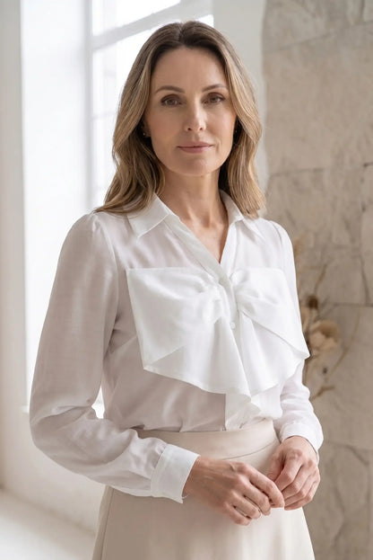 Camisa blanca de manga larga para mujer con lazo grande, look elegante y casual.