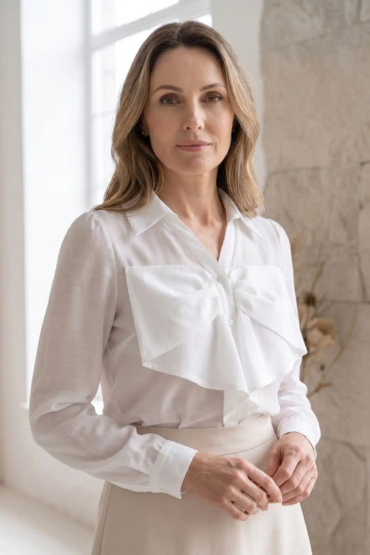 Camisa blanca de manga larga para mujer con lazo grande, look elegante y casual.