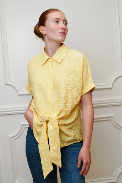 Mujer con camisa amarilla pastel de manga corta y lazo, moda casual de primavera