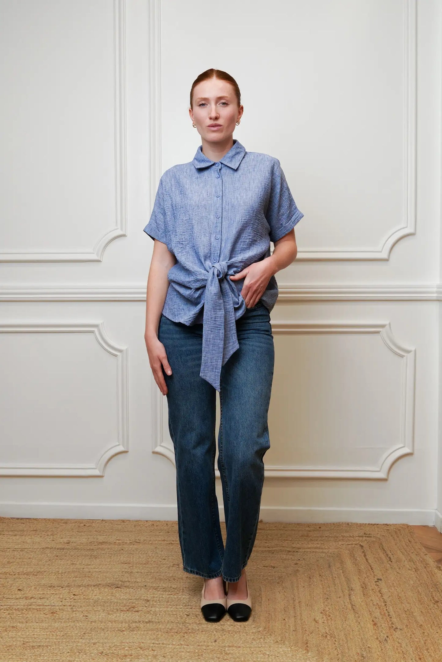 Mujer con camisa azul de manga corta anudada y jeans, look casual de primavera