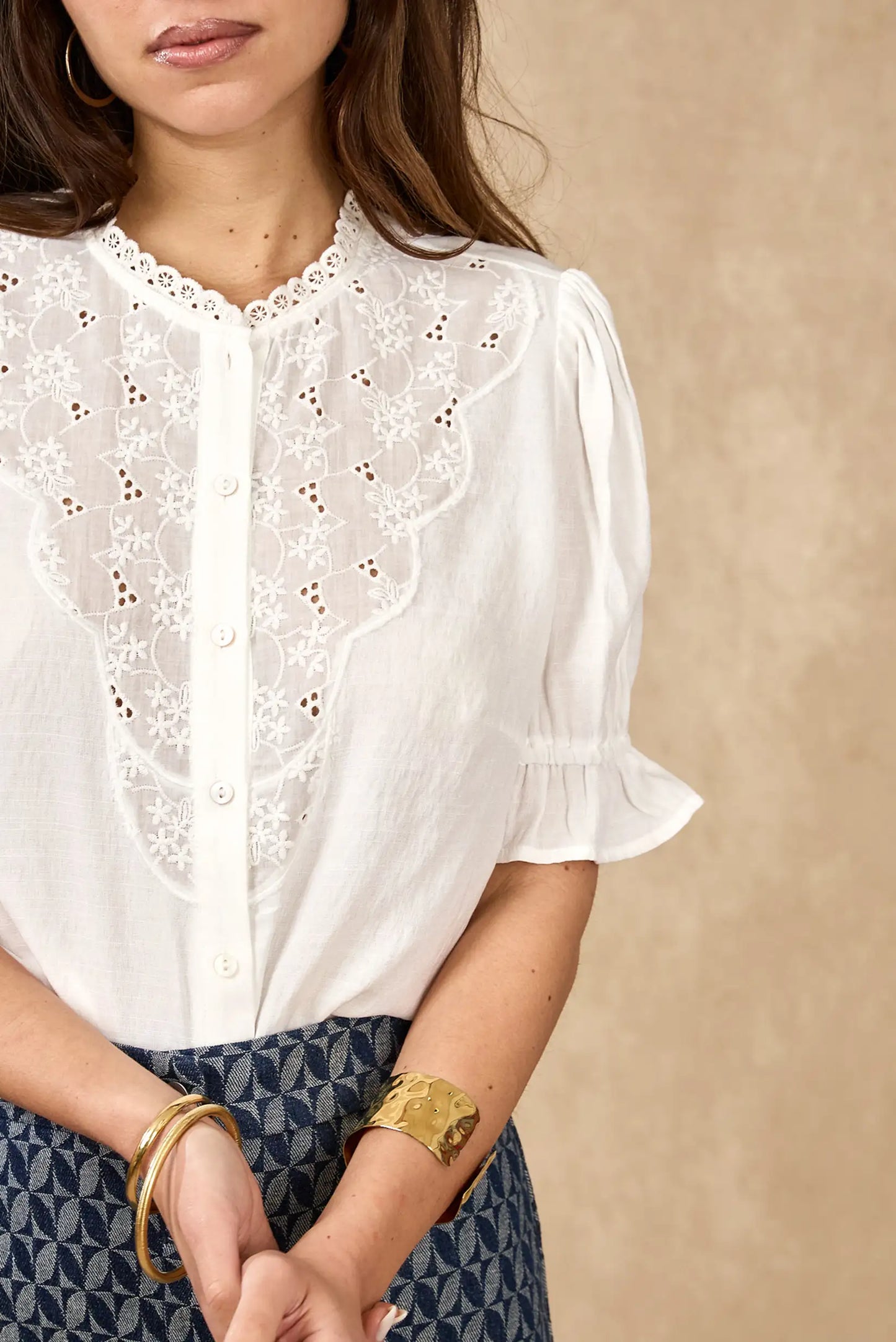 Blusa blanca de mujer con bordados florales y manga corta, estilo primavera elegante.