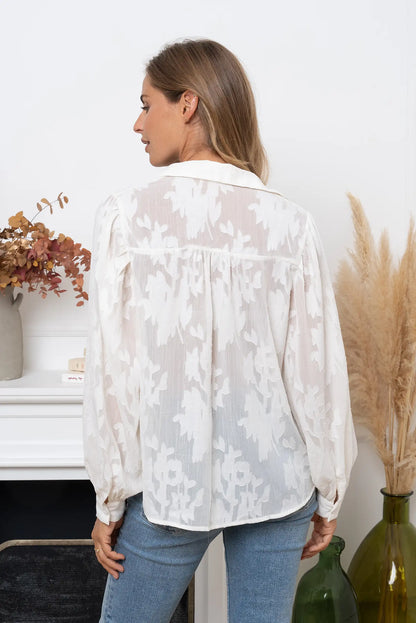 Blusa blanca roto semitransparente con estampado floral y manga larga en mujer de espaldas