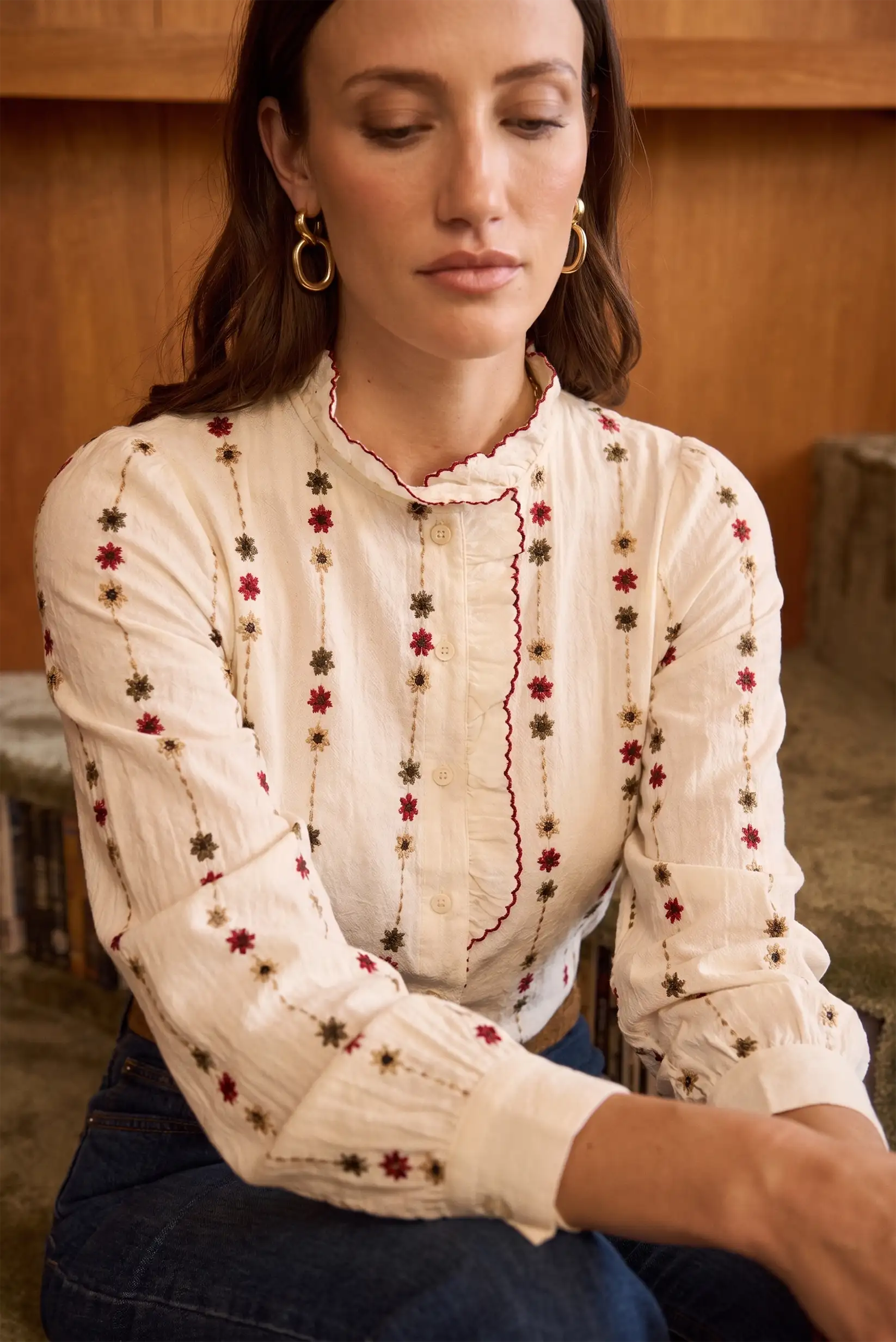 Blusa blanca con bordados florales rojos y marrones, cuello fruncido y mangas largas
