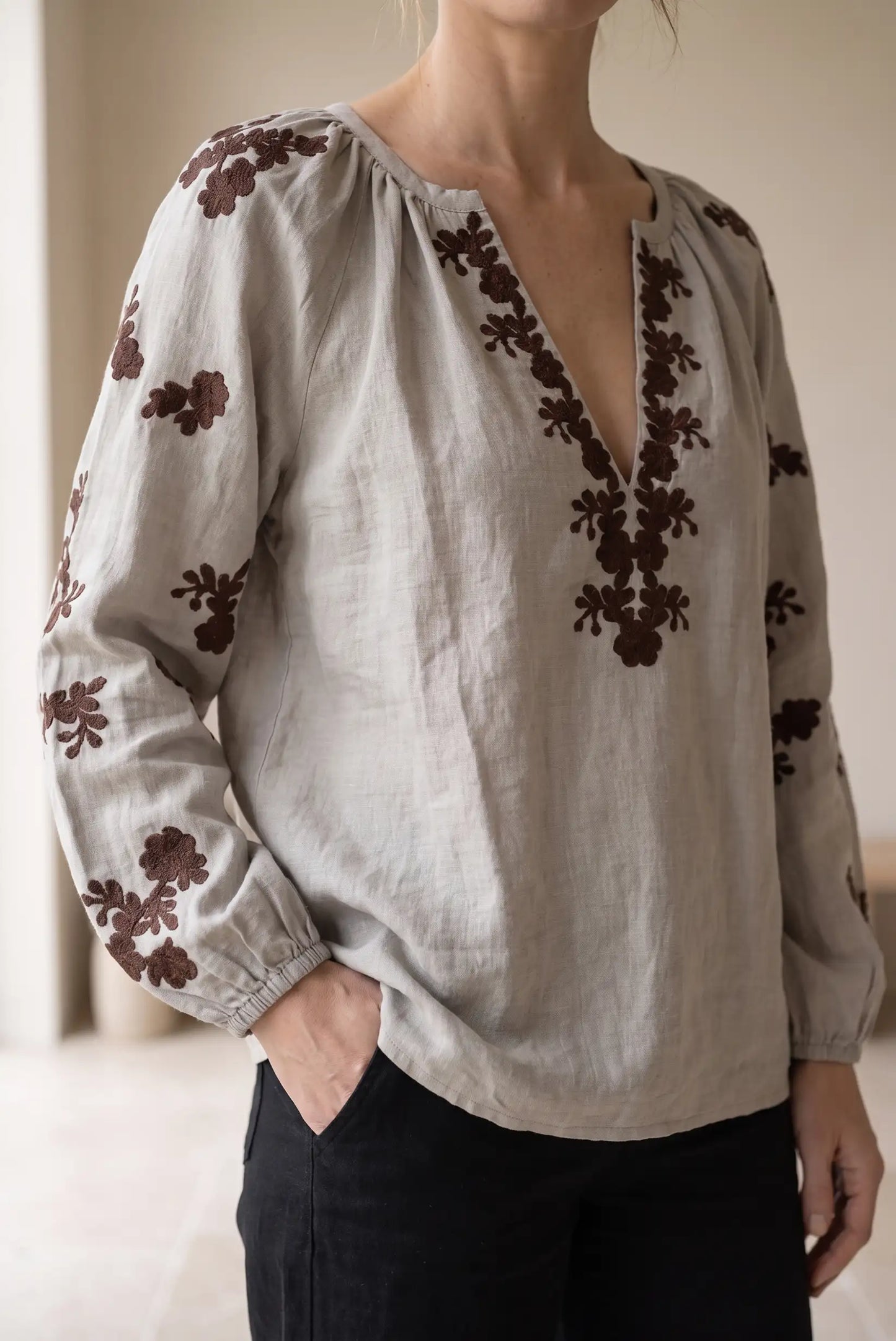 Blusa de lino gris con bordados florales marrones y escote en V